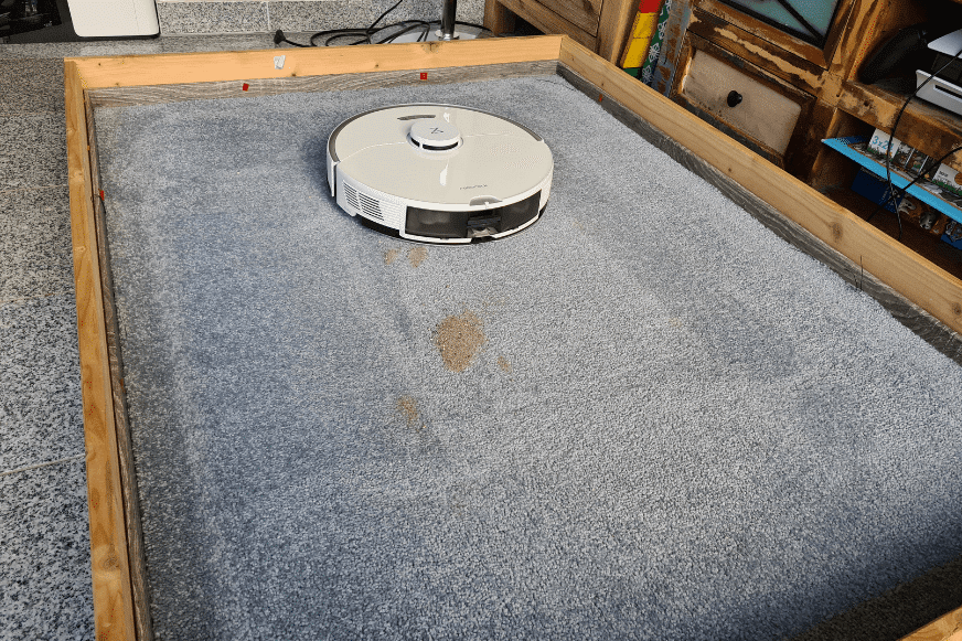 Roborock S7 Pro Ultra во время испытания на всасывание песка на ковре с высоким ворсом